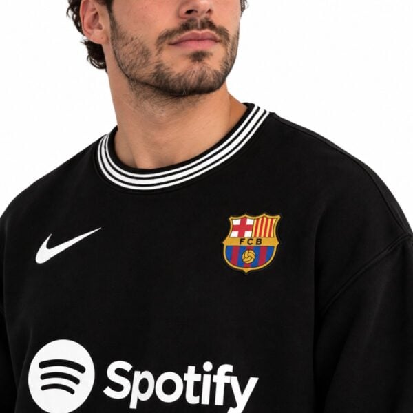 FC Barcelona black crewneck close up of the embroidered club crest Nike swoosh and striped ribbed collar