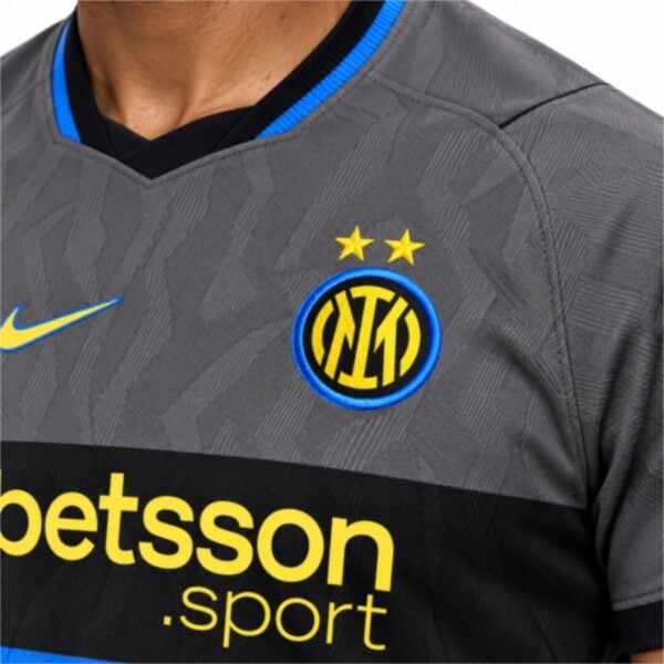 Inter Milan third jersey close-up of the IM crest with two gold stars and the blue and black V-neck