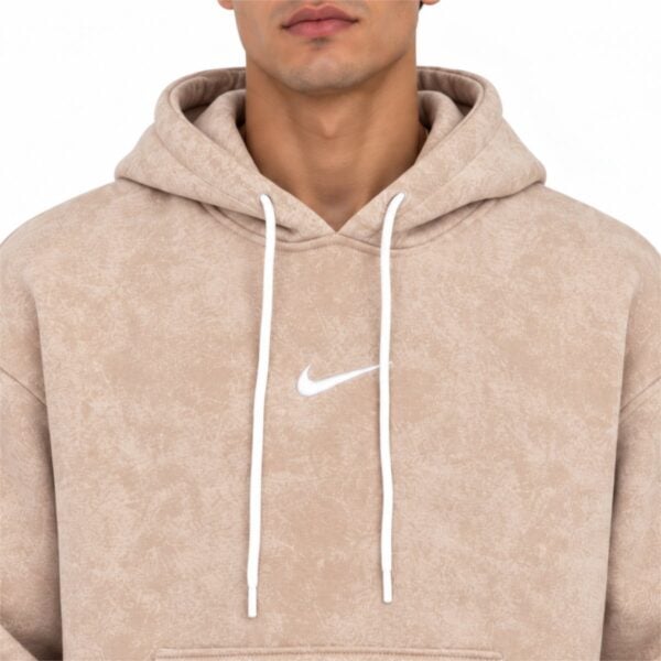 Nike washed hoodie close up of the white embroidered swoosh drawcords and acid wash fleece texture