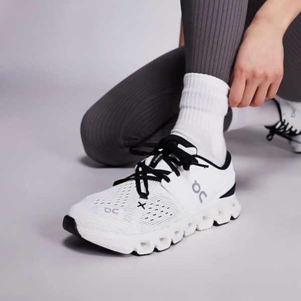 On Cloud X 4 Ivory Black worn on foot side view with the mesh upper and ON logo