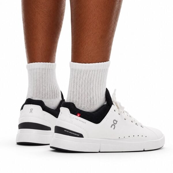 On The Roger Advantage white and black pair back view with Swiss cross and THE ROGER heel branding - UAE SPORT STORE On The Roger Advantage white and black sneakers back view with Swiss cross and THE ROGER heel branding