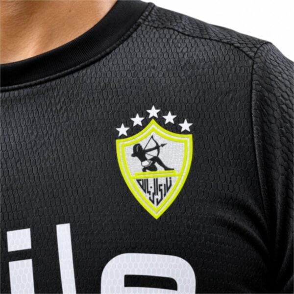 Zamalek away jersey close-up of the neon yellow crest and honeycomb textured black fabric