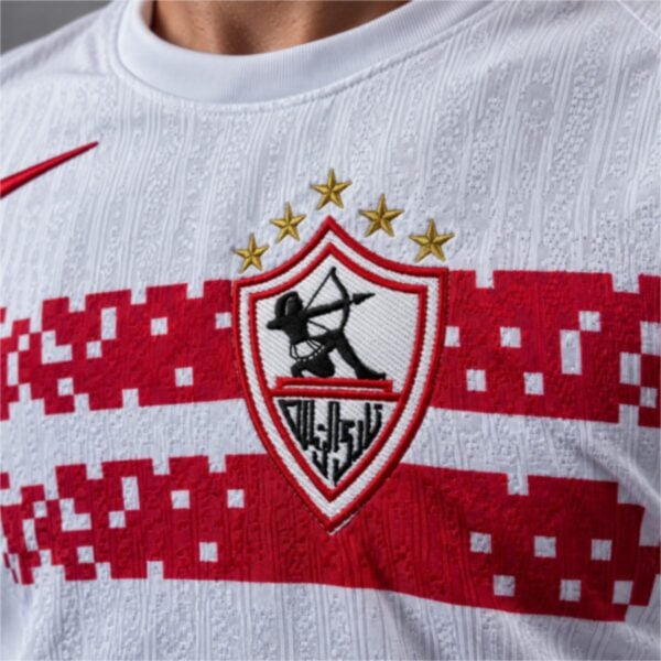 Zamalek home jersey close-up of the embroidered club shield with the archer and five gold stars